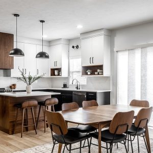 Luminoso open space con cucina e sala da pranzo sui toni del bianco,