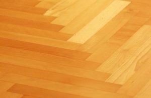 Dettaglio di un parquet a spina di pesce in legno dorato