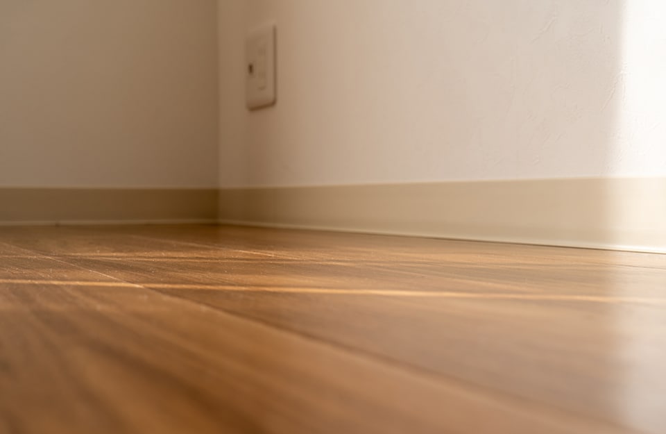 Vista dal basso di un angolo di stanza con parquet bruno-dorato