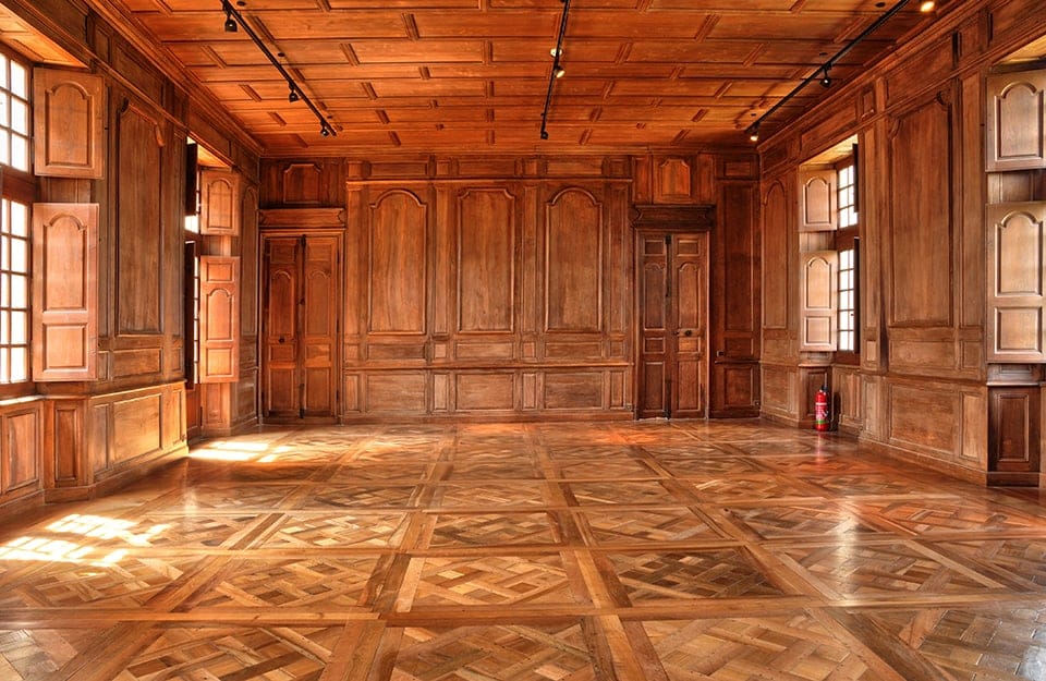 La stanza di un antico palazzo rivestita interamente in legno, dal soffitto a le pareti, con pavimento in parquet a quadrotte