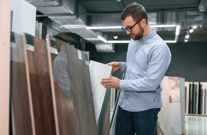 Un uomo sta valutando quale parquet acquistare in uno showroom di parquet