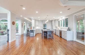 Grande e spaziosa cucina in una casa di lusso, con parquet molto lucido e finestre che danno sul patio