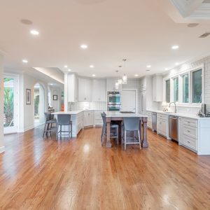 Grande e spaziosa cucina  in una casa di lusso, con parquet molto lucido e finestre che danno sul patio