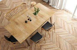 Vista dall'alto di una sala da pranzo in stile scandinavo, con tavolo in legno, sedie e pavimento in parquet a spina di pesce