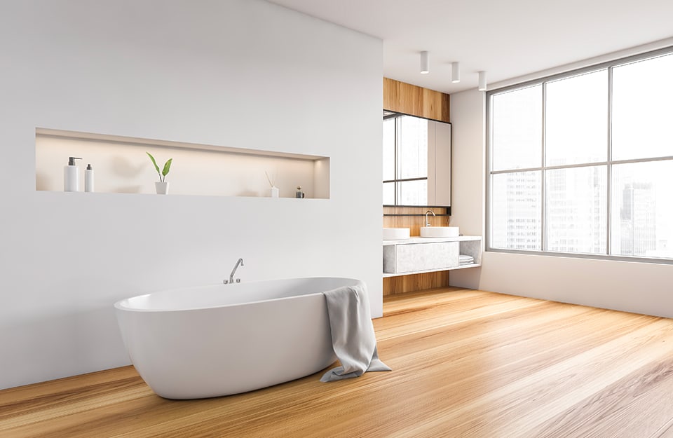 Luminoso e spazioso bagno sui toni del bianco e del legno, con grande vasca da bagno bianca e finestra in stile industriale