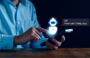 Immagine concettuale di un uomo che sta usando il suo smartphone dal quale sembra uscire un assistente virtuale dall'aspetto robotico, con su scritto sul petto AI, con accanto il fumetto che dice “Hi! How can I help you?”
