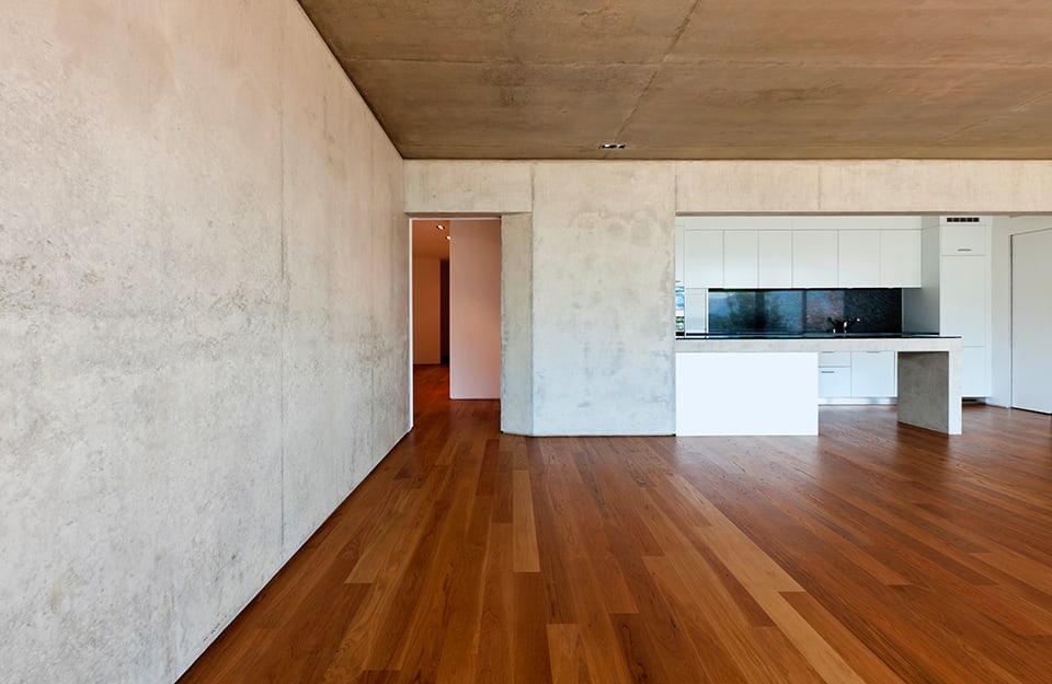 Stanza minimale e vuota con pareti e soffitto in cemento e pavimento in parquet