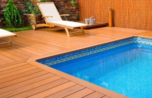 Esterno con decking a bordo piscina con sedie a sdraio