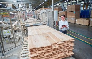 Una donna in una fabbrica di parquet sta controllando i prodotti