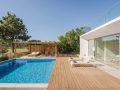 Giardino esterno di una villa di architettura modernista, con piscina e decking