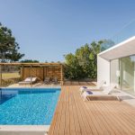 Giardino esterno di una villa di architettura modernista, con piscina e decking