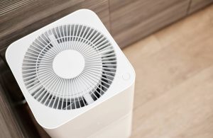 Vista dall'alto della ventola di un purificatore d'aria, in una stanza con parquet chiaro