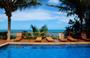 Piscina immersa nella natura tropicale, vicino al mare, con decking in legno esotico