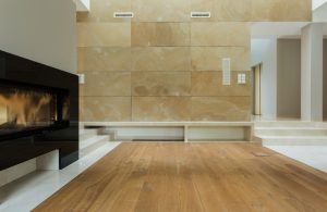 Salotto con pavimento in parquet e grande televisore, con pareti in marmo giallo