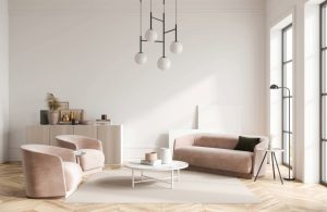 Salotto con arredi moderni dalle linee curve, sui toni del bianco e del rosa pastello, con pavimento in parquet chiaro a spina di pesce