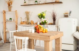 Zona living shabby chic con tavolo grezzo, credenza vintage e parquet in rovere naturale