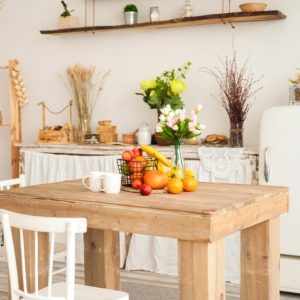 Zona living shabby chic con tavolo grezzo, credenza vintage e parquet in rovere naturale