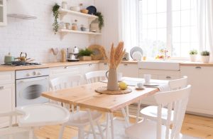Cucina shabby chic con parquet in pino naturale, tavolo rustico e sedie bianche