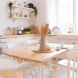 Cucina shabby chic con parquet in pino naturale, tavolo rustico e sedie bianche