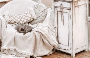 Angolo shabby chic con poltrona in tessuto neutro, mobiletto decapato e parquet rovere sbiancato